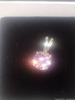 Front view of sterling silver pendant with round pink gemstone