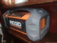 Left side view showing Ridgid logo, grey bumper, carry handle