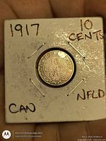 Front of coin in holder showing reverse legend and date