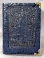 Front view of coin bank showing embossed New York Life building