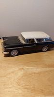 Side view of black and white 1955 Chevrolet Nomad die-cast model