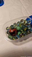 Top view of plastic container filled with assorted marbles