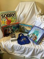 Group shot of all items: three board games, two puzzles, tote bag