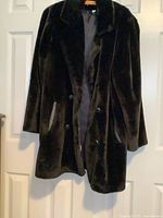 Front view of black faux fur jacket hanging