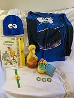 Overall view of clothing, book, toys and small items laid on bed