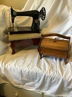 Singer machine on ottoman beside closed sewing box