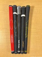 Front view of five golf grips showing branding and colors