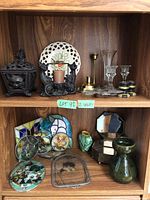 Overall view of both shelves showing assortment of metal, glass, ceramic and resin decor items