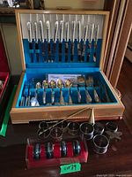 Overall lot: open flatware chest, napkin rings, candle snuffer visible