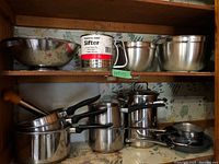 Overall view: mixing bowls, colander, flour sifter, stock pot, saucepans, frying pans