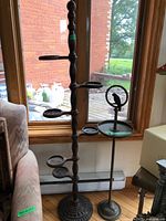 Full view of wooden plant stand beside metal bird feeder