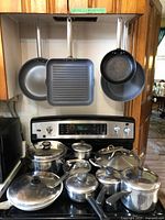 Overall view of cookware on stove and hanging above