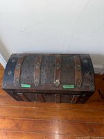 Top view of dome-top trunk showing metal panels, wood slats, hardware