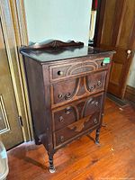 Full view of dark wood four-drawer dresser
