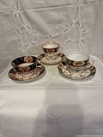 Three teacup and saucer sets displayed face up