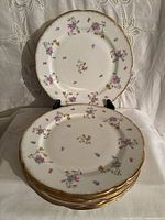 Stack of eight Royal Crown Violets Pompadour dinner plates with one plate displayed upright