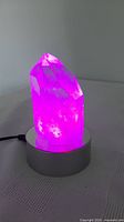 Quartz crystal illuminated pink on LED base