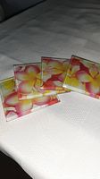 Four square glass coasters with flower design laid out