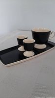 Tray, cup and two egg cups grouped on table