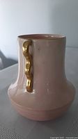 Front view showing pink glaze and one gold wavy handle