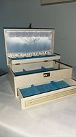 Box open showing satin lid, removable tray, blue velvet compartments