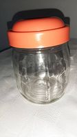 Glass jar with orange plastic lid assembled