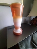 Full view of caramel and white milk glass vase standing upright