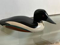 Full side view of carved duck decoy showing overall form and paint scheme