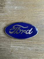 Front view of oval blue enamel Ford radiator badge