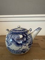 front view of blue and white ceramic teapot with lid and spout