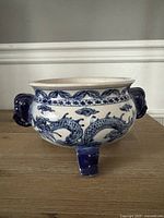 overall view of pot showing dragon design, handles, feet