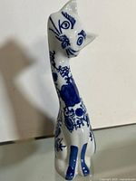 Full side view of blue and white ceramic cat figurine