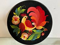 Full view of round wooden plate with rooster and flowers
