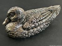 Front and side view of silver-tone metal duck figurine