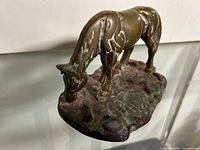Front angle view of brass grazing horse on base