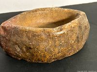 Top angle of carved stone mortar showing shape and cavity