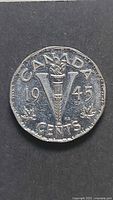 Reverse of 1945 Canadian 5-cent coin showing torch and V design