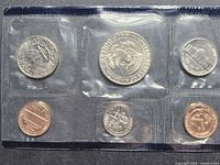 front of sealed coin set showing reverse sides of five coins and mint token