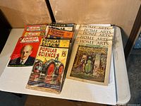 Overview of assorted magazines on table, showing Popular Science, Radio Craft, Home Arts