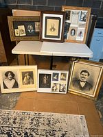 Group view of all framed photographs displayed on table and floor
