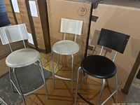Front view of three IKEA bar stools showing seats, backs and metal legs