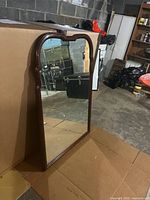 Front view of mahogany framed mirror showing arched top and reflective surface