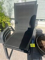 Front view of stack of three black sling patio chairs