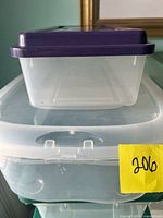 Stack of assorted clear bins showing small purple-lid bin atop medium and large bins