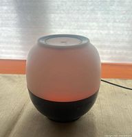 Diffuser lamp illuminated red showing overall shape and cord