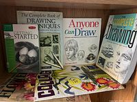 Front view of six art instruction books on shelf