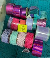 Group of ribbon spools showing glitter and floral lace designs