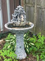 Full view of resin pedestal fountain in garden setting