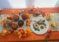 Overview of garland, glitter pumpkins and embroidery hoop on table