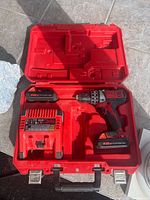 Entire kit opened: drill with battery, spare battery, charger, fitted case
